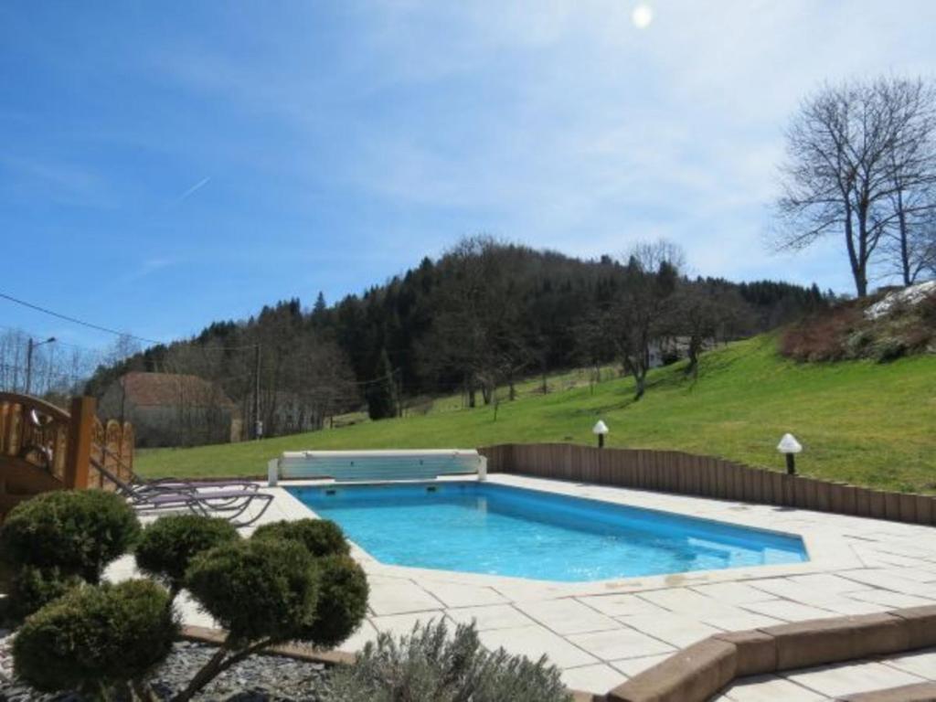 a swimming pool in a yard with a hill at Gîte Ferdrupt, 2 pièces, 2 personnes - FR-1-589-101 in Ferdrupt