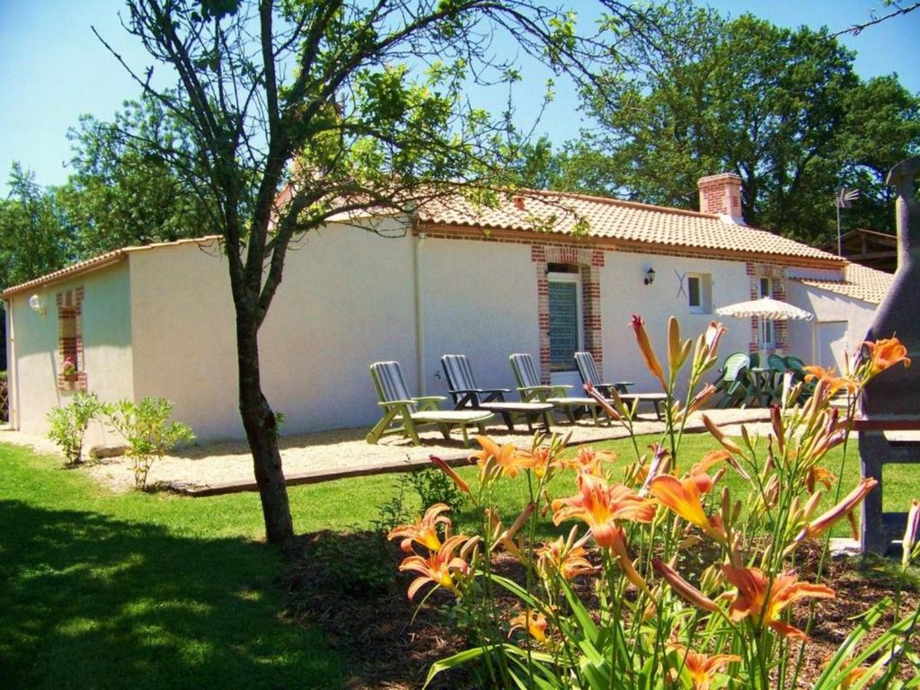een huis met een tafel en stoelen in een tuin bij Gîte La Garnache, 4 pièces, 6 personnes - FR-1-426-195 in La Garnache