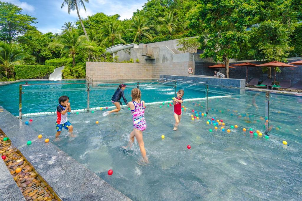a group of children playing with balls in a swimming pool at Sunsuri Phuket - SHA Plus in Nai Harn Beach