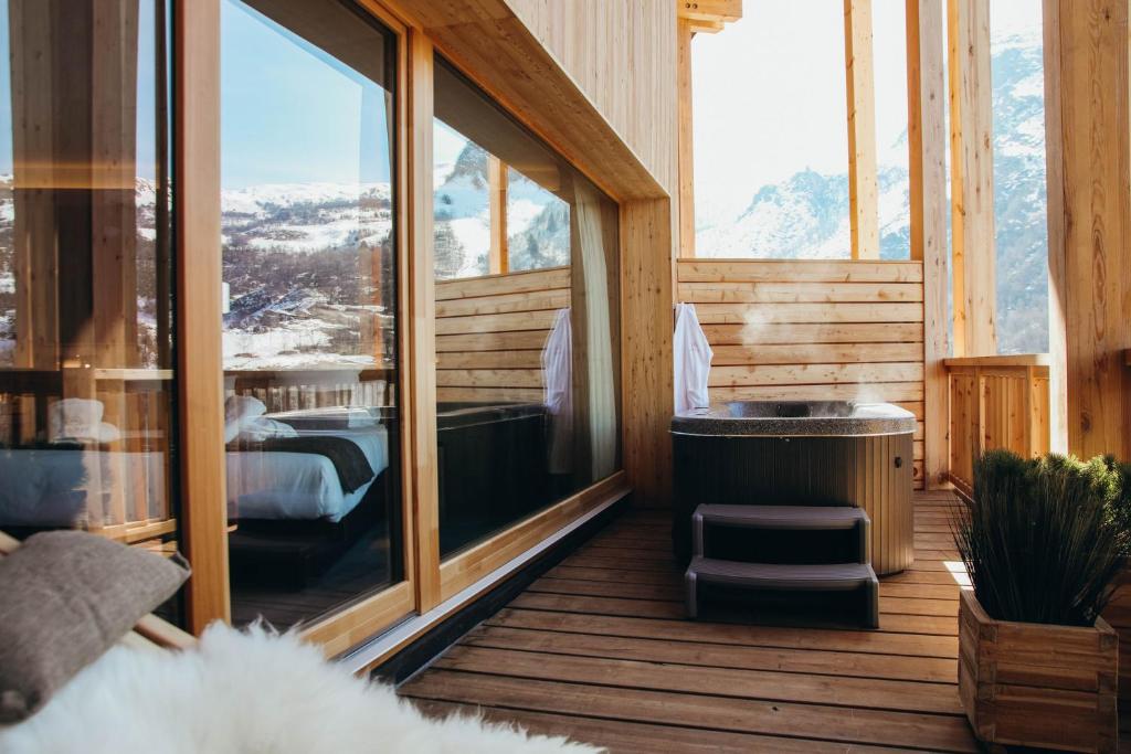 a room with a bed and a view of a mountain at Lodji Hotel & spa in Saint-Martin-de-Belleville