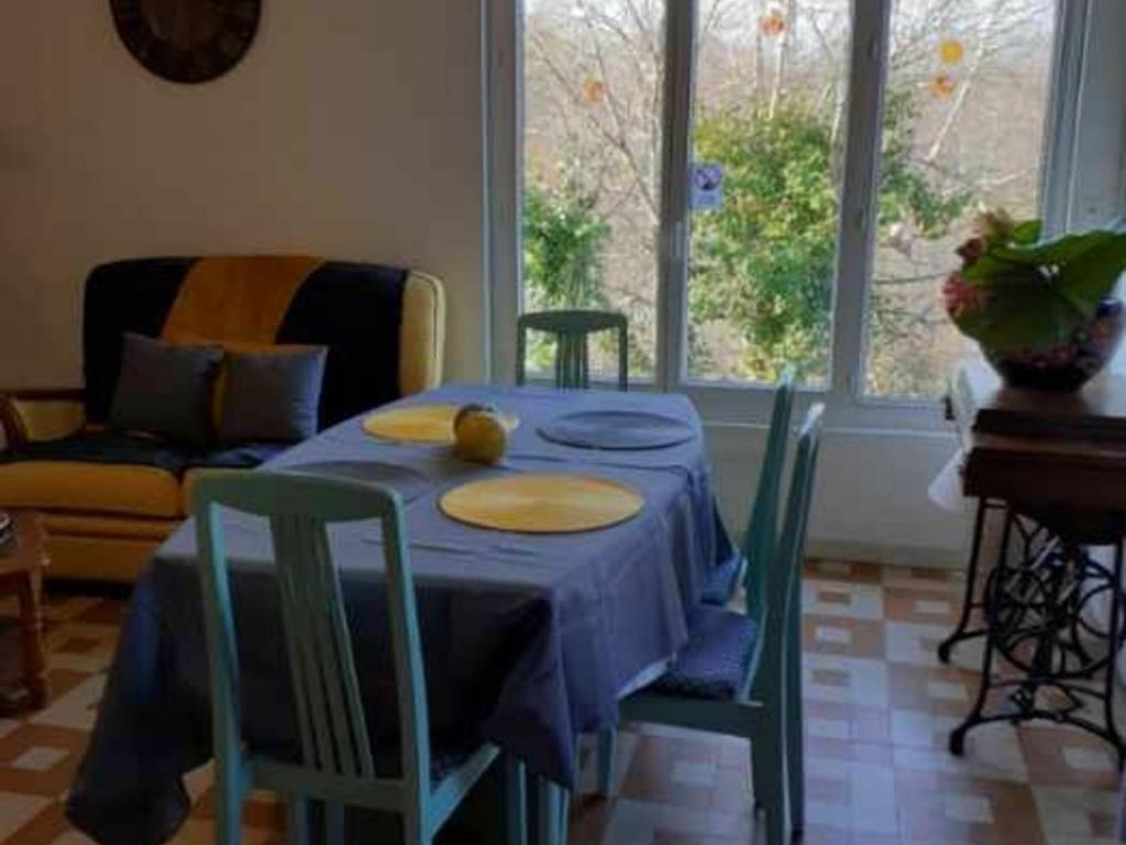 une table avec un chiffon bleu et des chaises dans une pièce dans l'établissement Gîte Dampierre-en-Burly, 3 pièces, 5 personnes - FR-1-590-223, à Dampierre-en-Burly