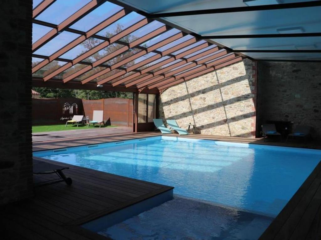 una piscina con pergolato e una piscina di Gîte Les Herbiers, 6 pièces, 10 personnes - FR-1-426-406 a Les Herbiers