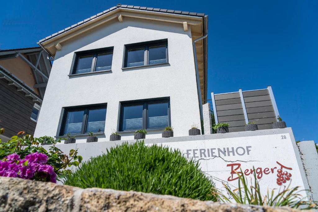 een wit gebouw met een bord ervoor bij Ferienhof Berger UG in Hagnau