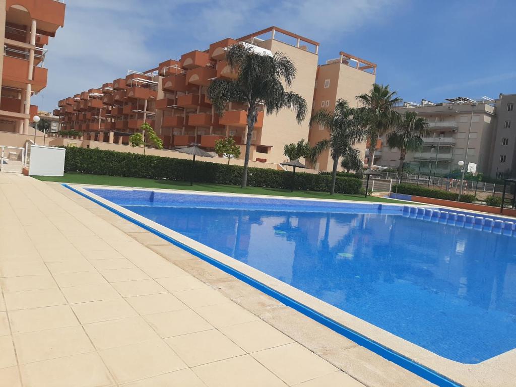 a large swimming pool in front of a building at Apartamento playa canet d'en Berenguer in Canet de Berenguer