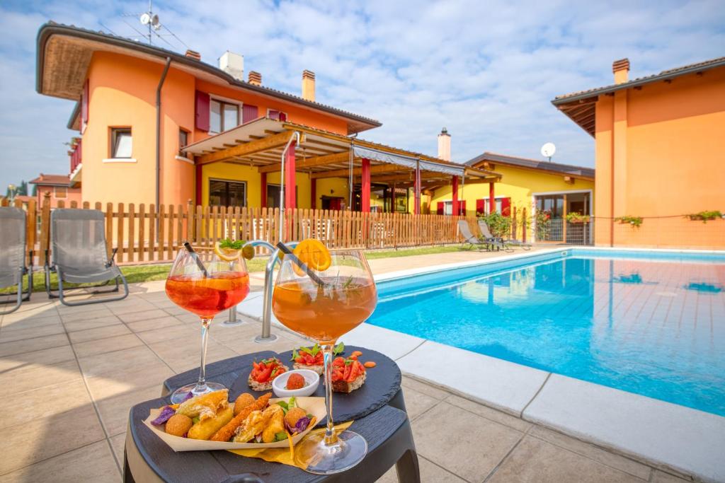 einen Tisch mit zwei Gläsern Wein und einem Teller Essen in der Unterkunft Villa Camporosso in Colà di Lazise