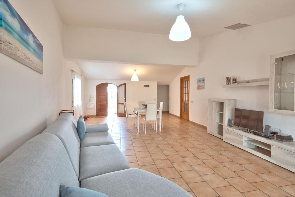 ein Wohnzimmer mit einem blauen Sofa und einer Küche in der Unterkunft Appartamento Zia Lucia in Terme Vigliatore