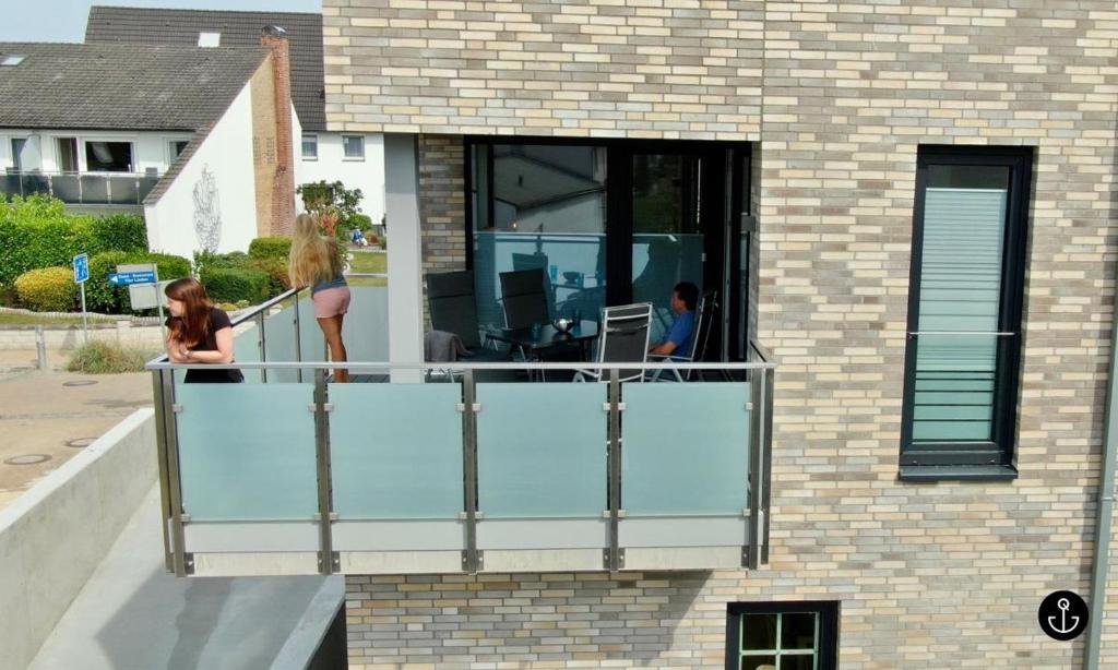 two women standing on a balcony of a house at Sonnengarten 4 - Sonnenveranda in Kellenhusen