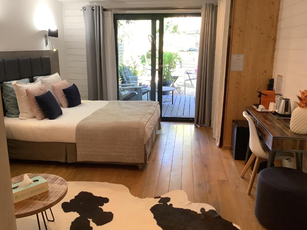 Schlafzimmer mit einem Bett, einem Tisch und einem Schreibtisch in der Unterkunft Hôtel Monet in Honfleur