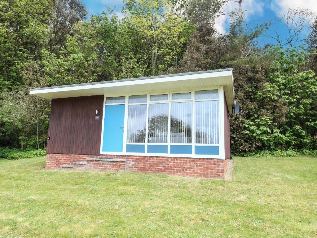 una casa con una gran ventana en un patio en Chalet 126a en Cromer