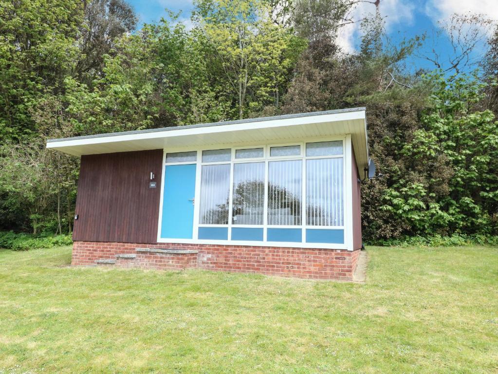a house with a large window in a yard at Chalet 126a in Cromer