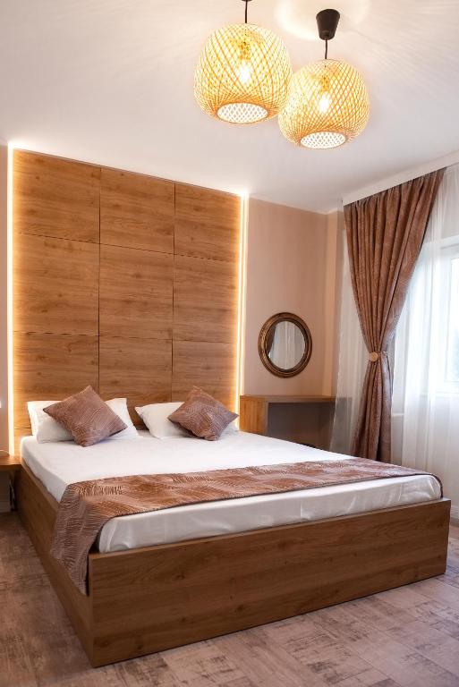 a bedroom with a large bed and two lights at Anastasia SeaSide in Mangalia