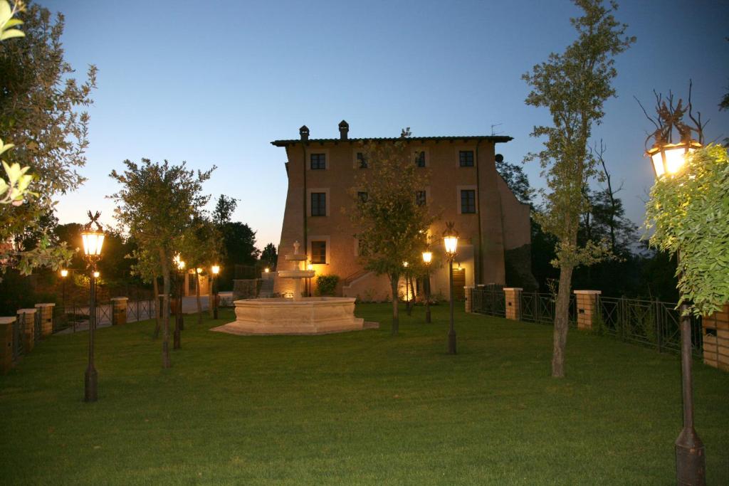 a building with lights in a park at night at Relais Castrum Boccea in Boccea