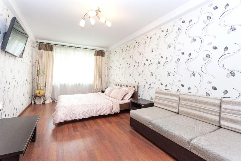 1 dormitorio con 1 cama y 1 sofá en Studiominsk 8 Apartments, en Minsk