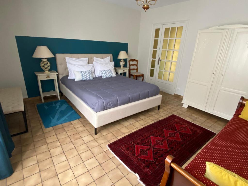 a bedroom with a bed with blue sheets and pillows at "LA VERANDA" Gîte in Verdigny