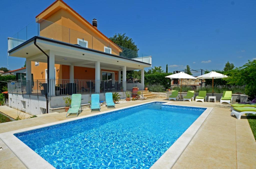 a villa with a swimming pool in front of a house at Villa Margherita in Kanfanar