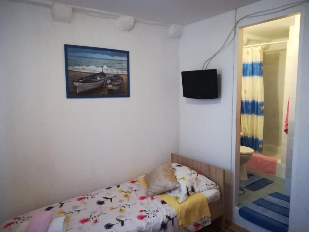 um pequeno quarto com uma cama e um espelho em Room Center Old Town em Dubrovnik