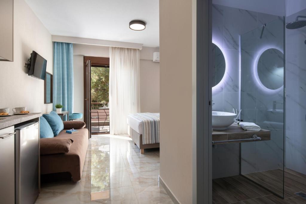 a bathroom with a couch and a sink in a room at VagAthan - Lux Holidays in Afitos