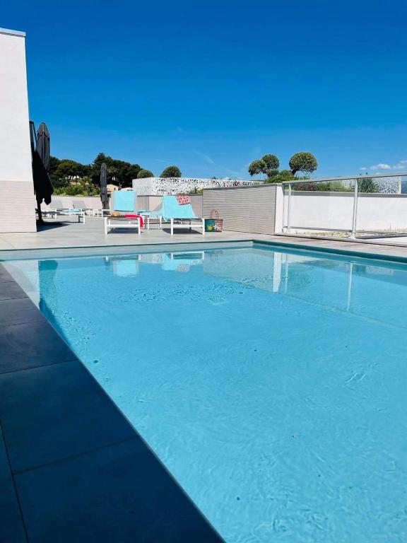 a large swimming pool with blue water at Lagrange Apart&#39;Hôtel Antibes Olympie in Antibes