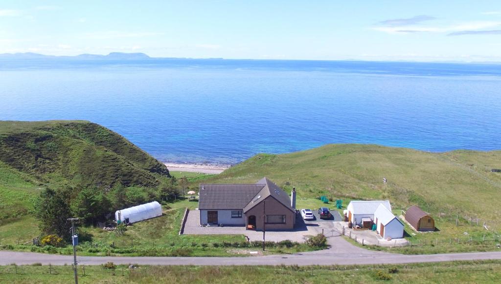 an aerial view of a house on a hill next to the ocean at Shiskine in Gairloch