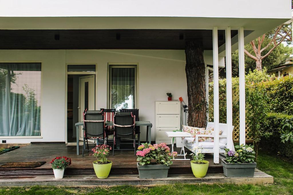 a porch with chairs and a table with plants at Ivy Lalzi Bay Beach House in Durrës