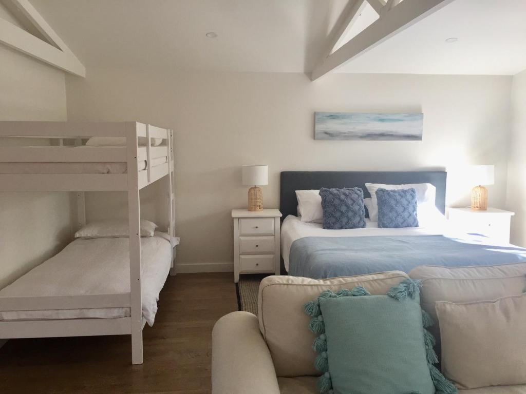 a bedroom with a bunk bed and a couch at Bijoux Beach House in Freshwater