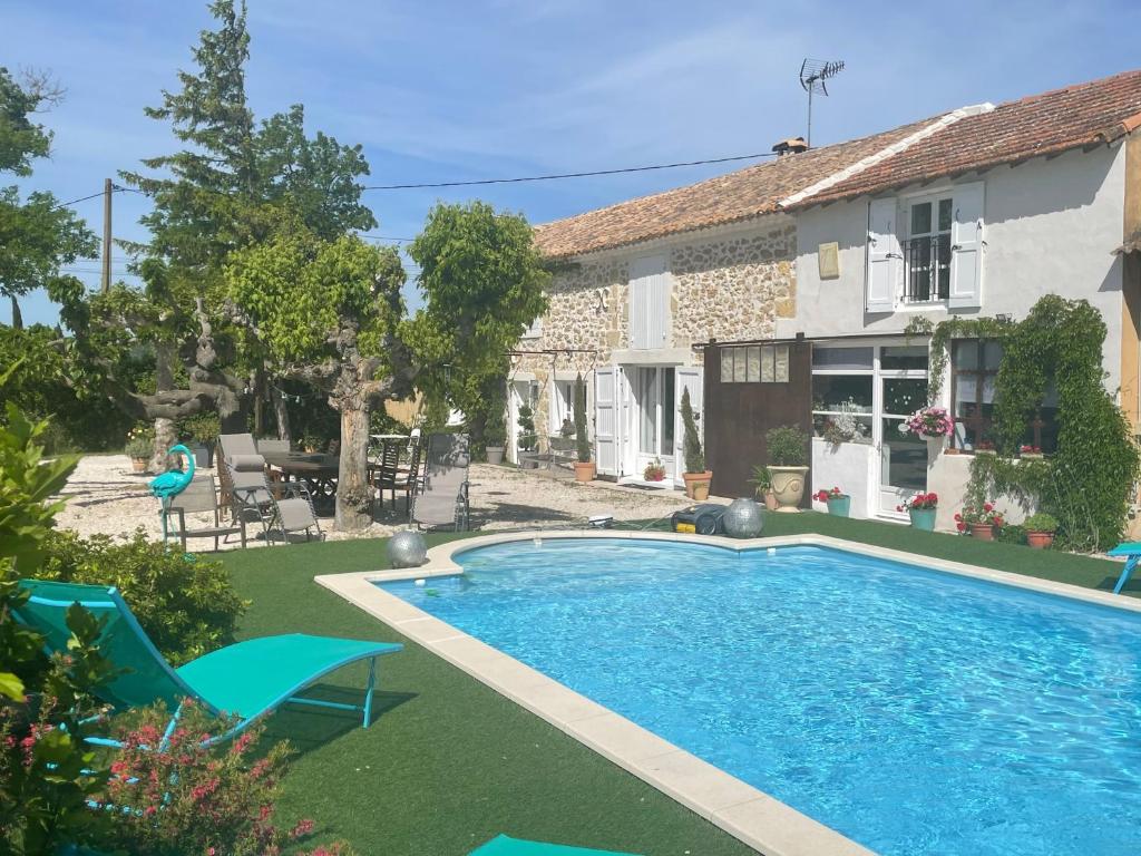 a villa with a swimming pool in front of a house at Appt 2 pieces dans Mas provençal in Roquemaure