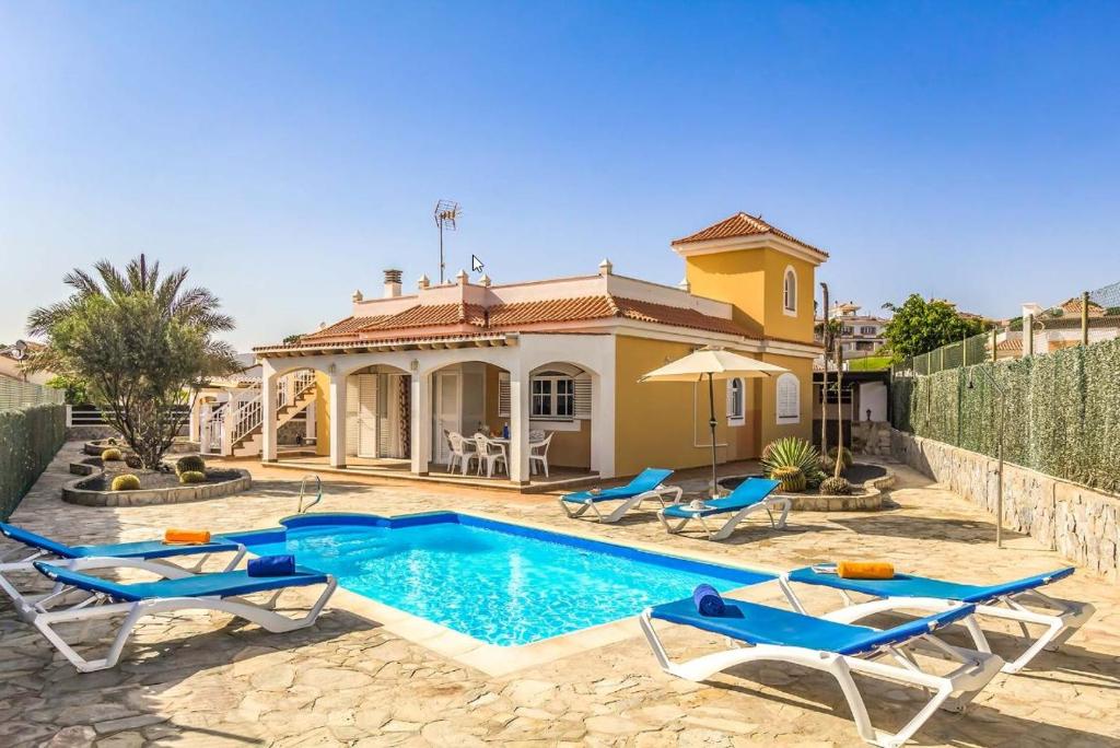 a villa with a swimming pool in front of a house at Vv Tirma in Caleta De Fuste