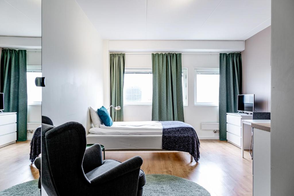a hotel room with a bed and two chairs at Part-Time Home Rotebro in Rotebro