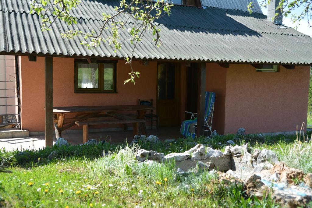 uma casa com uma mesa de piquenique em frente em Vikend kuca Stefana em Šljivovica