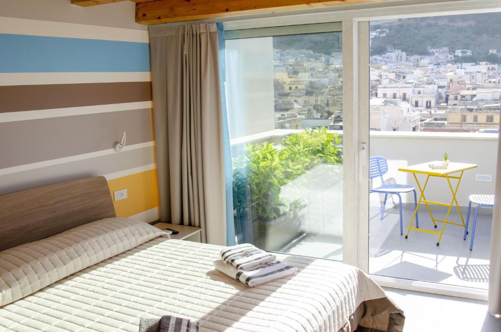 Solemare Casa Vacanze في كاستيلاماري ديل غولفو: غرفة نوم بسرير ونافذة كبيرة