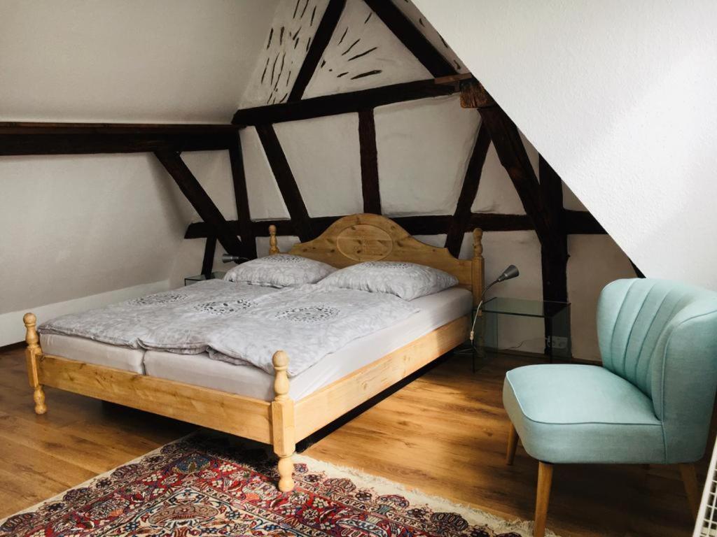 a bedroom with a bed and a blue chair at Rheingau - schöne möblierte Ferienwohnung in Eltville