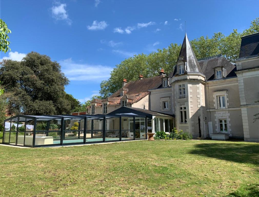 an exterior view of a mansion with a large yard at Château l&#39;Hubertière, classé du tourisme 4 étoiles in Bouresse