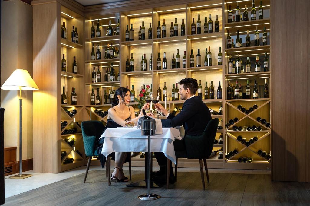 a man and woman sitting at a table in a wine cellar at A Hoteli - Hotel Izvor in Arandelovac