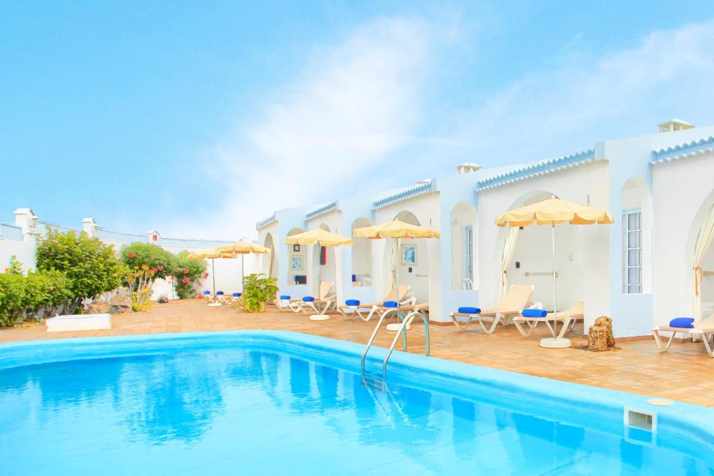 een villa met een zwembad in een resort bij Neptuno Bungalows - Adults Only in Corralejo