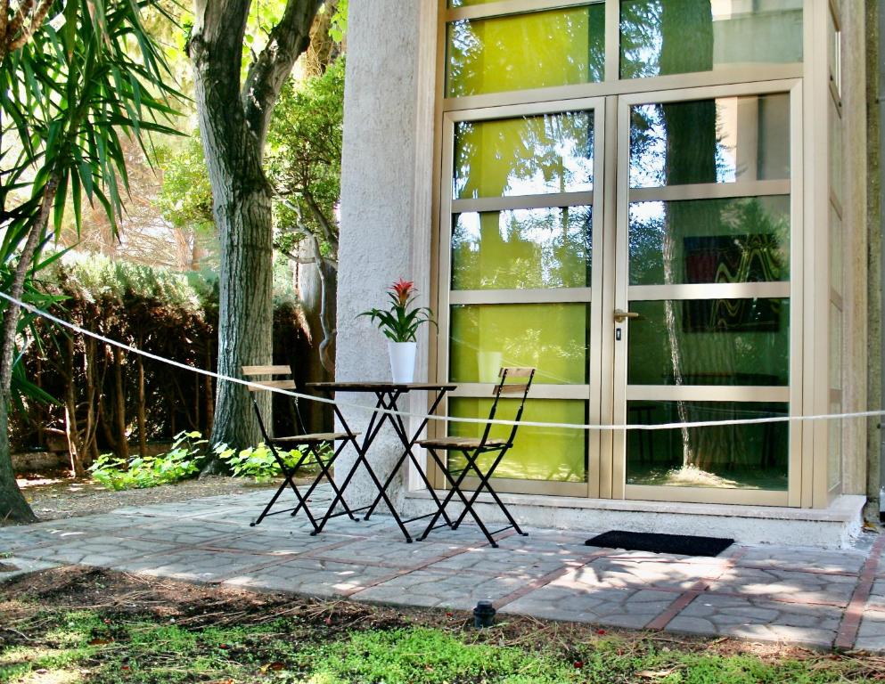 une table et des chaises devant une fenêtre dans l'établissement BuenRetiroPe - confortevoli bilocali con giardino, à Pescara