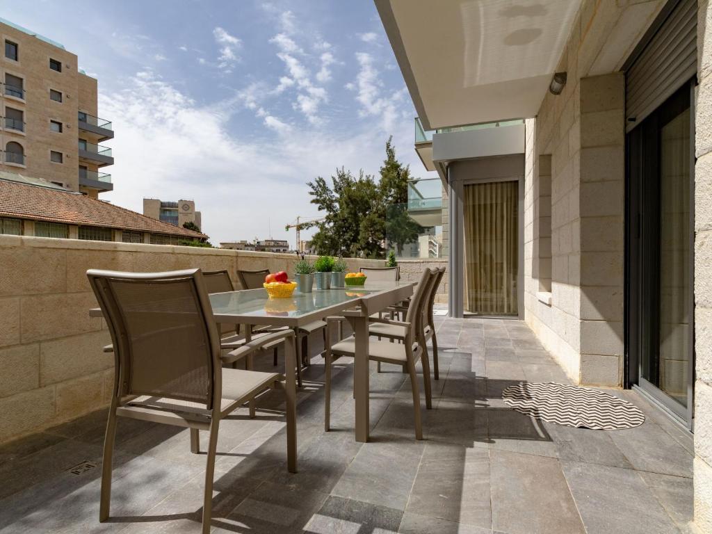 patio con mesa y sillas en el balcón en Harav agan - 9 people - Full Option, en Jerusalén