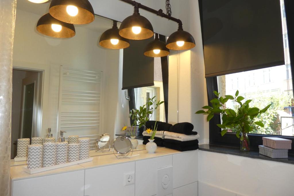 a bathroom with three lights hanging over a counter at Stylische FeWo in Meißen (Nähe Elbe, eigener Eingang, EG, Terrasse) in Meißen