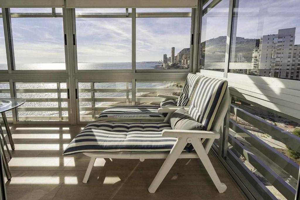 アリカンテにあるBalcon de Ulises Alicante Playaの窓付きのバルコニーの上にベンチが備わります。