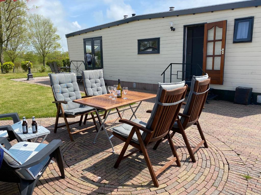 een patio met een tafel en stoelen en een gebouw bij Vakantiehuisje Makkum NL - S15 in Makkum