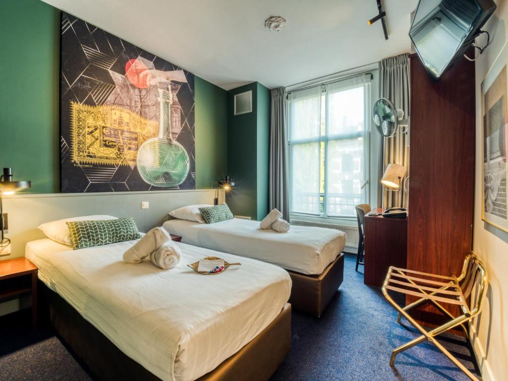 a bedroom with a large bed and a large window at Hotel Alexander in Amsterdam