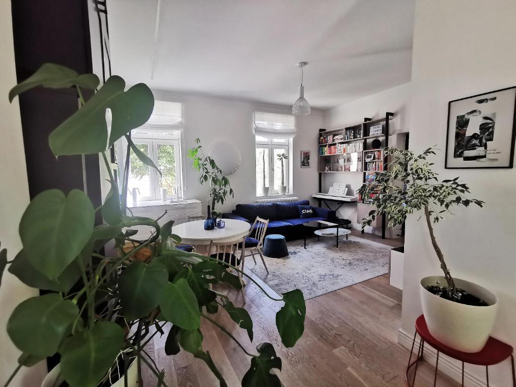 ein Wohnzimmer mit einem Sofa und einem Tisch mit Pflanzen in der Unterkunft Retro Apartment in Sopot Center in Sopot