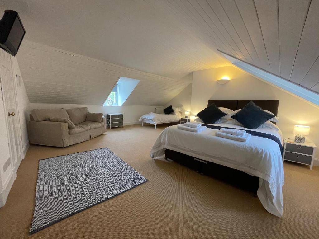 ein Schlafzimmer mit einem Bett und einem Sofa im Dachgeschoss in der Unterkunft Kelso cobbles in Kelso
