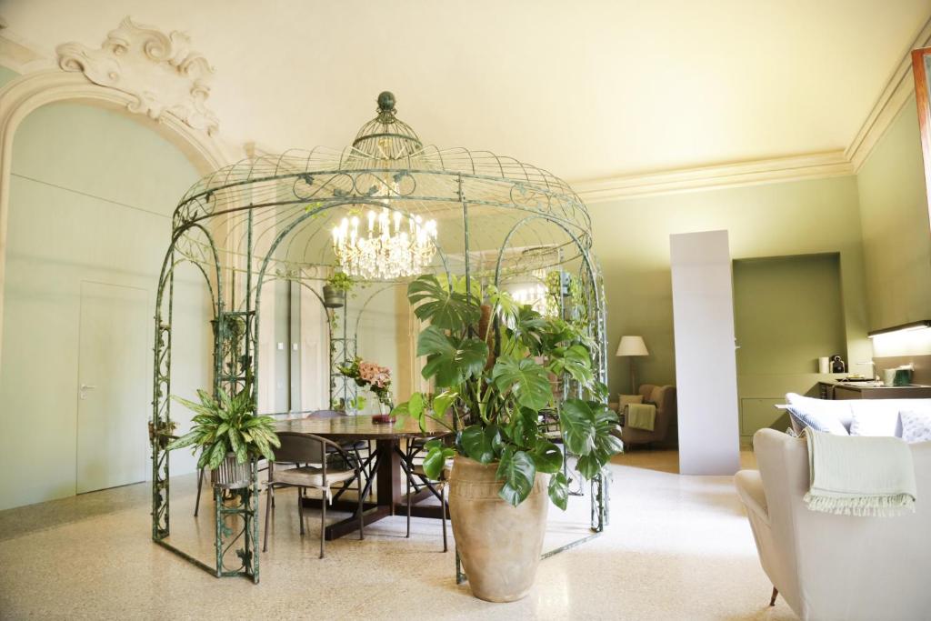 uma sala de jantar com um espelho e uma mesa com plantas em Atelier Pallavicini Suites em Bolonha