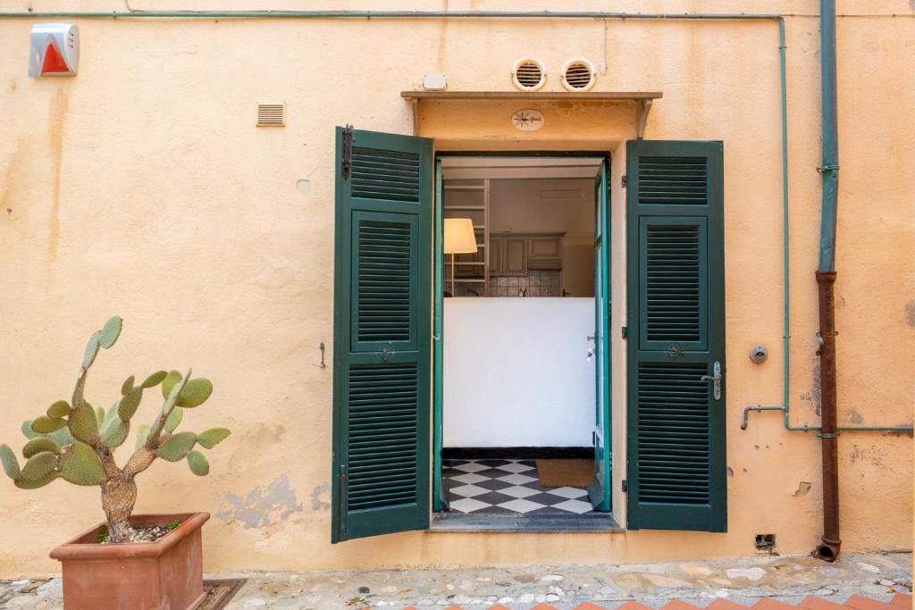 eine offene Tür eines Gebäudes mit einer Topfpflanze in der Unterkunft Le Casasse "Grecale" in Varigotti