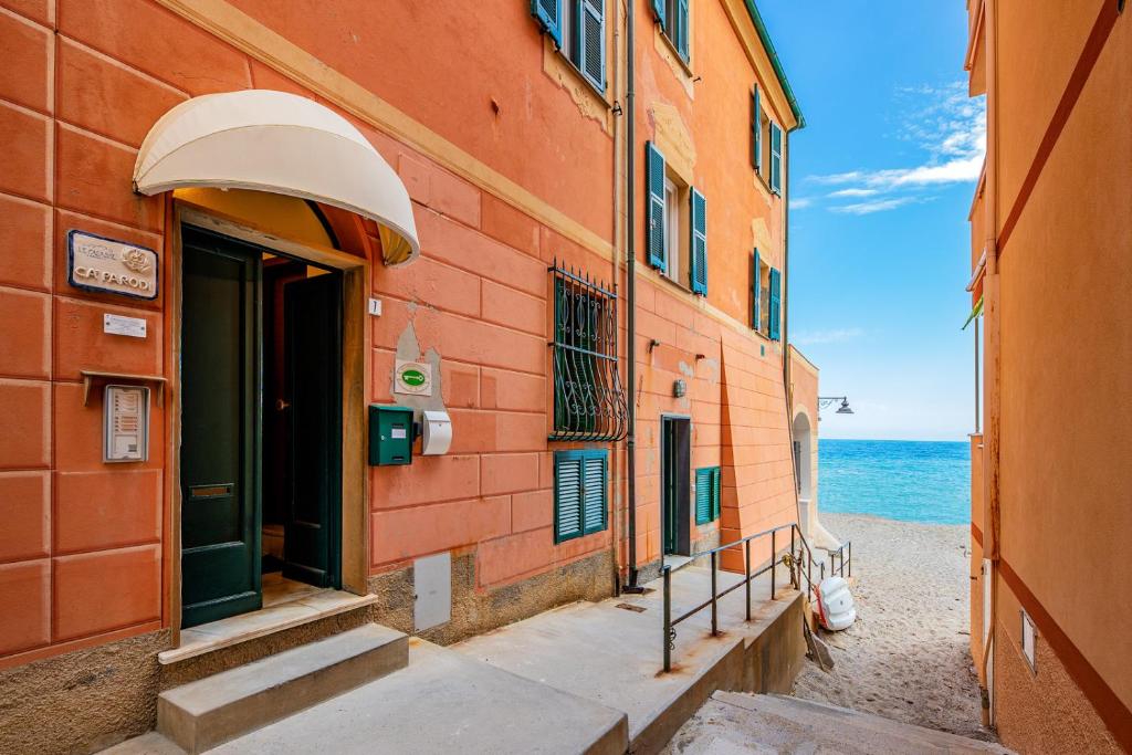 un bâtiment dans une rue avec l'océan en arrière-plan dans l'établissement Le Casasse, à Varigotti