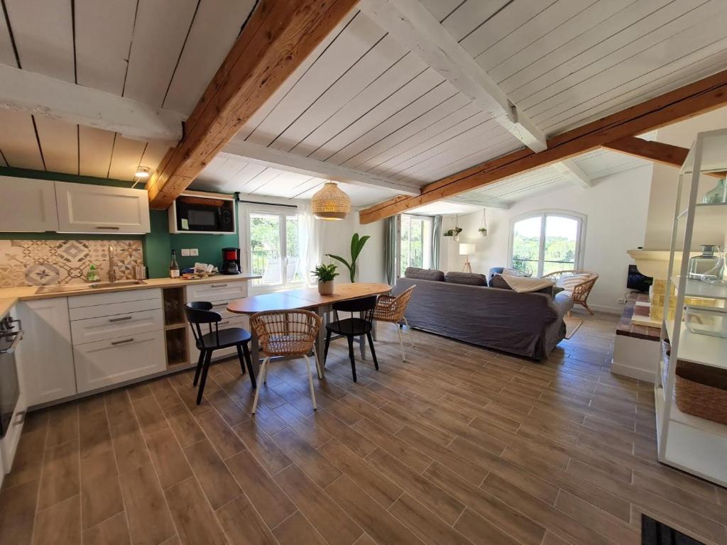 a kitchen and living room with a table and chairs at Domaine de la Navicelle in Le Pradet