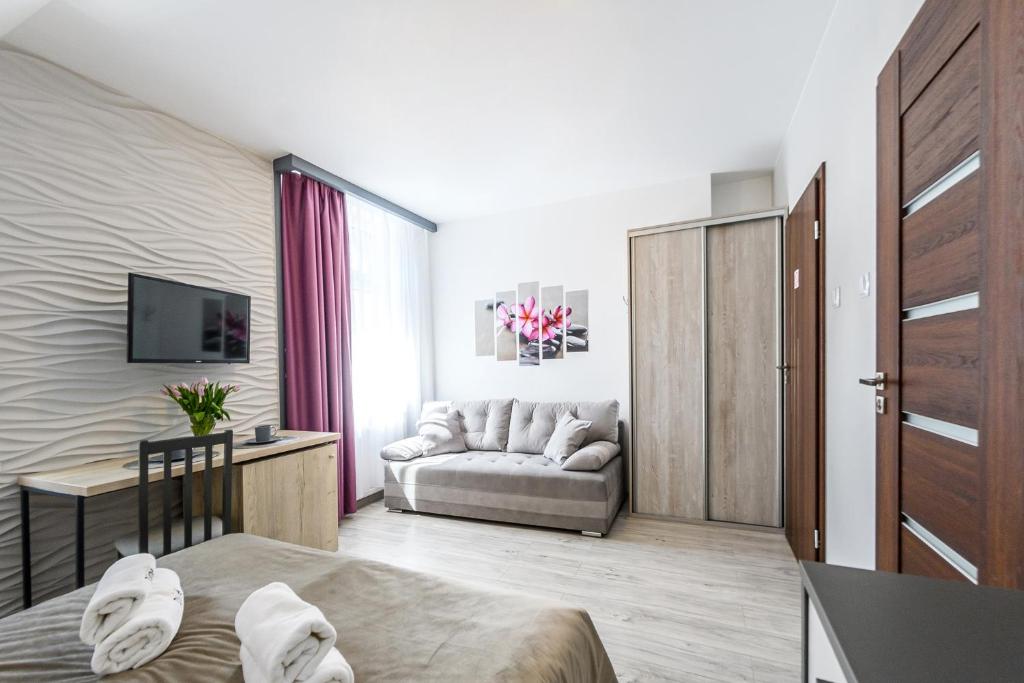 Una televisión o centro de entretenimiento en Pokoje, Noclegi, Apartamenty Dune Resort Łeba