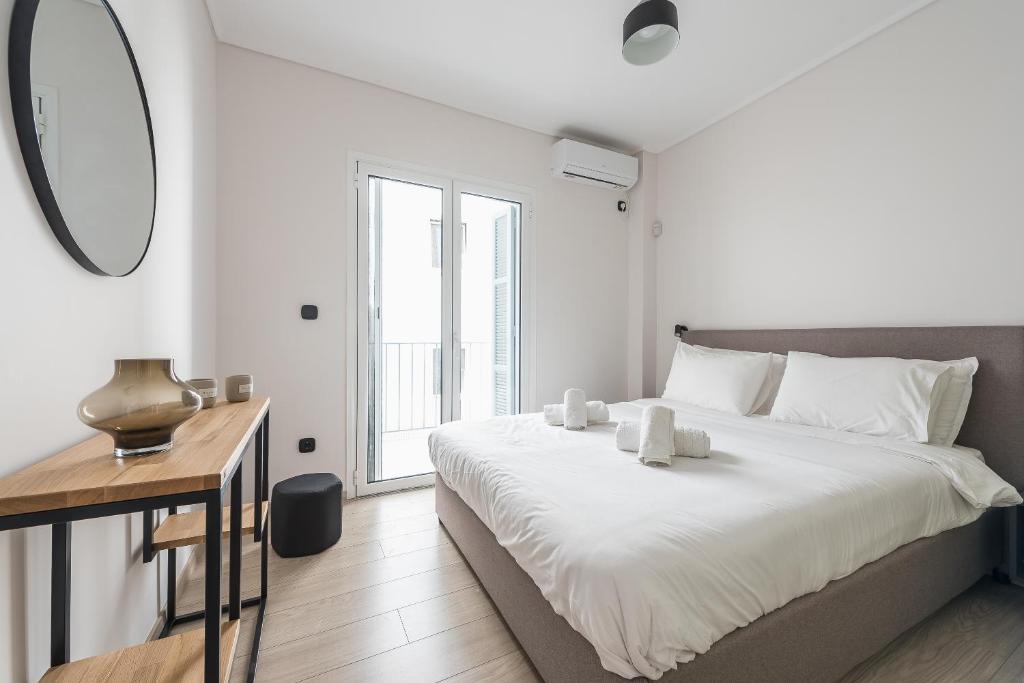 A bed or beds in a room at Petraki Residence 1bdr Apt with balcony 1 min from Ermou str