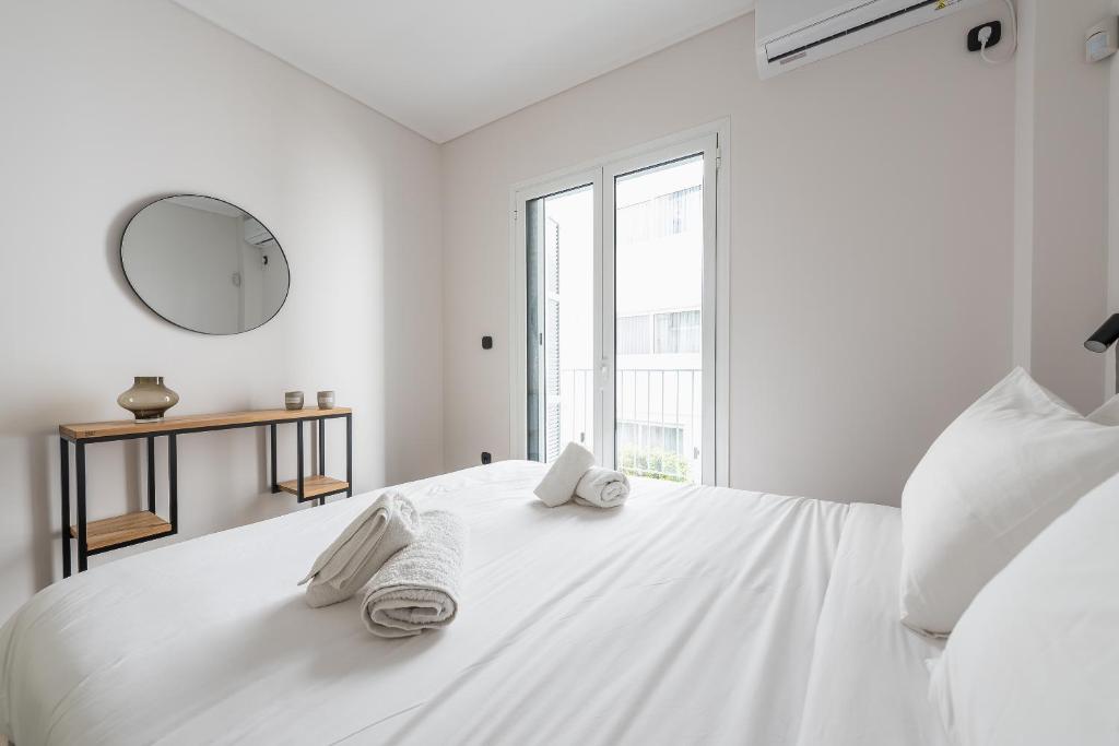 A bed or beds in a room at Petraki Residence 1bdr Apt with balcony 1 min from Ermou str
