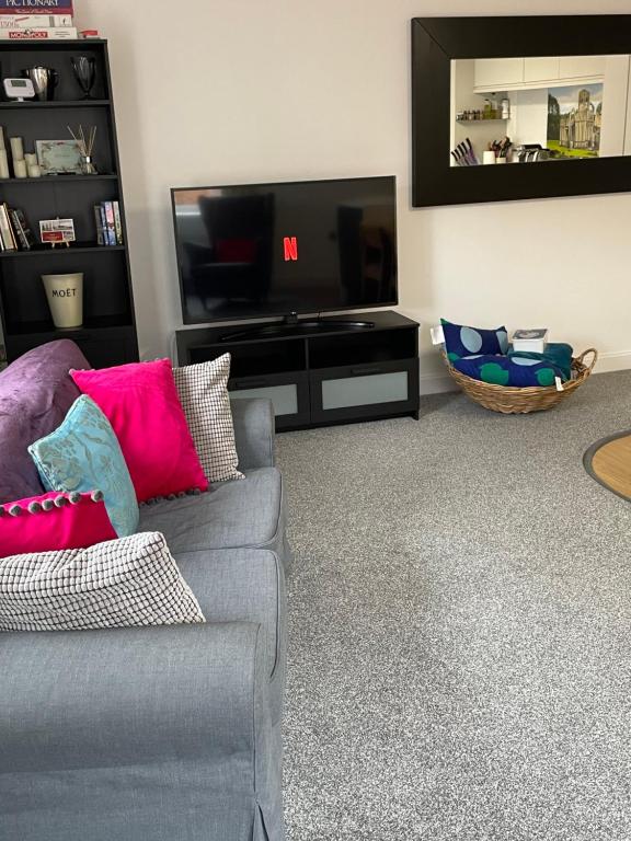 sala de estar con sofá y TV de pantalla plana en Luxury Two Bed Apartment in the City of Ripon, North Yorkshire en Ripon
